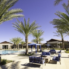 Pool deck area with swimming pool, blue canopies, and a fireplace with blue patio furniture