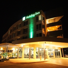 Front facing view of Holiday Inn at night with green accent lighting