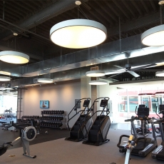 Fitness center with hanging lighting fixtures and ceiling fans