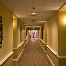 Hallway with lighting fixtures on wall